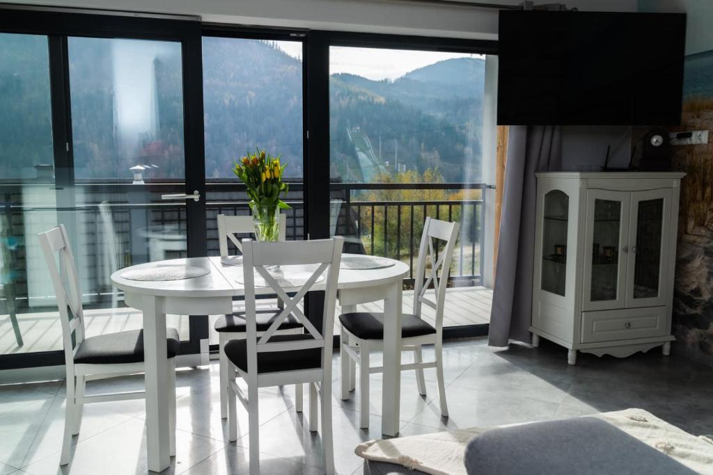 un tavolo bianco con sedie in una camera con balcone di ApartView Szkolna Szczyrk by Rent like home a Szczyrk