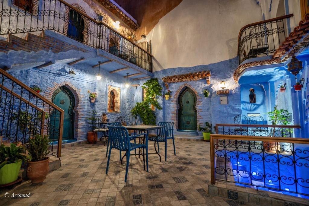 une pièce avec une table et des chaises dans un bâtiment dans l'établissement Riad ALHAMBRA, à Chefchaouen