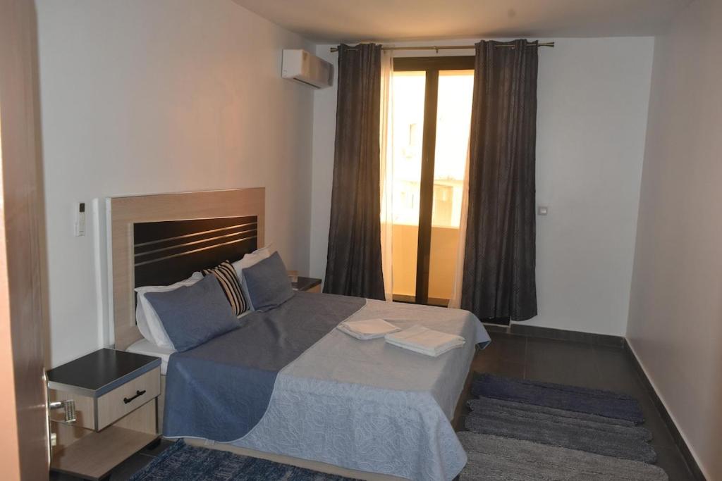 a bedroom with a large bed and a window at Appartement aux Mamelles in Dakar
