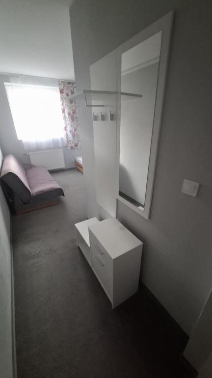 a small white room with a mirror and a sink at Gościniec 