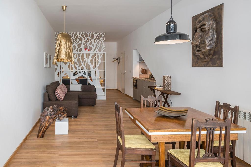 comedor y sala de estar con mesa y sillas en Art apartment in downtown Porto, en Oporto