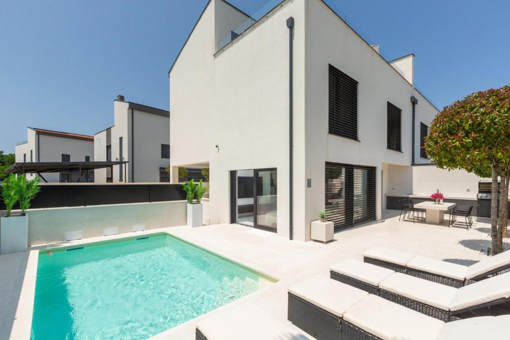 an exterior view of a house with a swimming pool at Villa Verana with pool in Savudrija