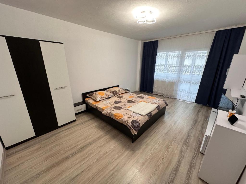 a bedroom with a bed and a large window at Cazare Herculane in Băile Herculane