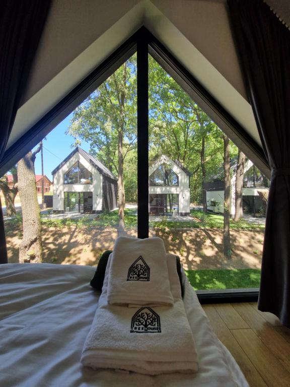 ein Bett im Zelt mit zwei Handtüchern in der Unterkunft Treehouses in Skorochow