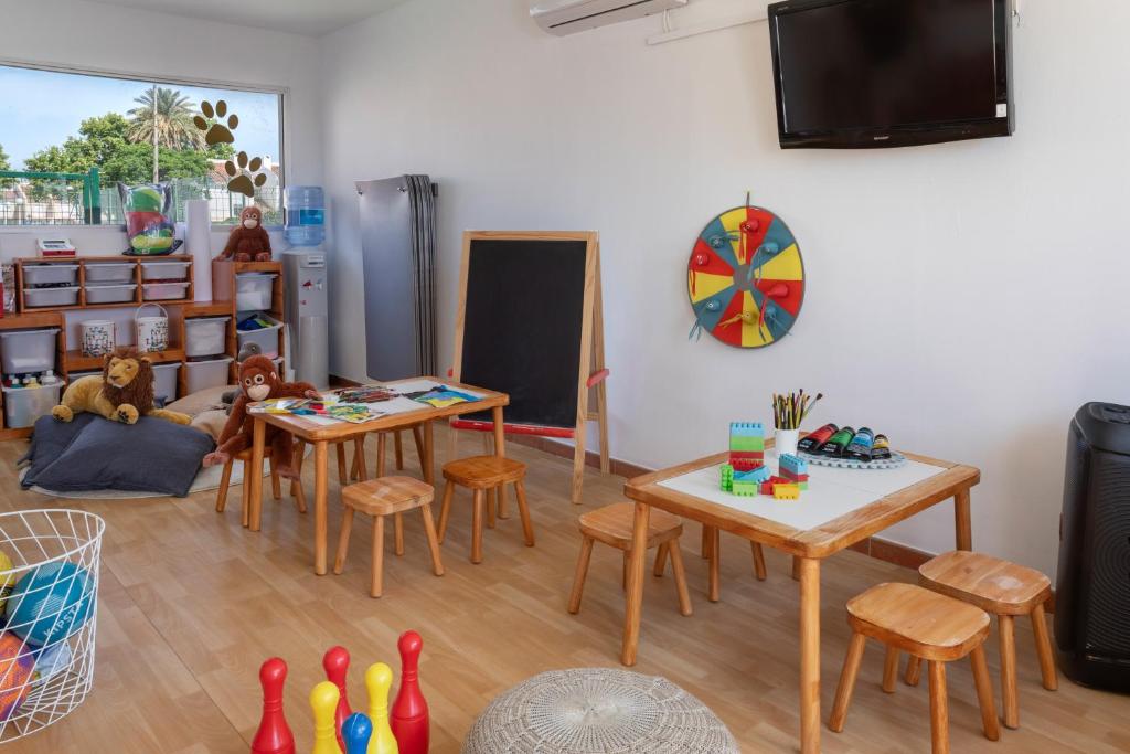 a living room with tables and chairs and a tv at Sol Guadalmar in Málaga