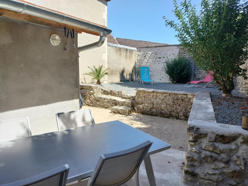 a table and chairs in the backyard of a house at La petite maison de poncho in Le Blanc