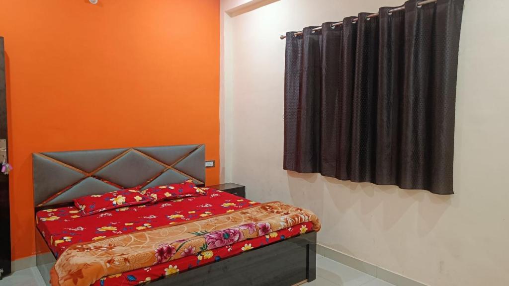 FaizābādArya guest house的一间卧室配有红色的床和黑色窗帘