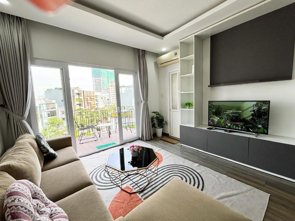 a living room with a large flat screen tv at Modern Garden Apt by Dragon bridge in Da Nang
