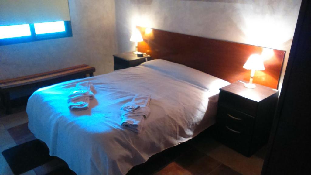 Un dormitorio con una cama blanca con toallas. en CABAÑAS LDM en San Isidro