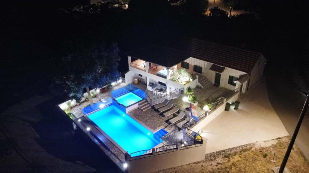 an overhead view of a house with a swimming pool at night at Villa Stipanovi Dvori in Vodenjak