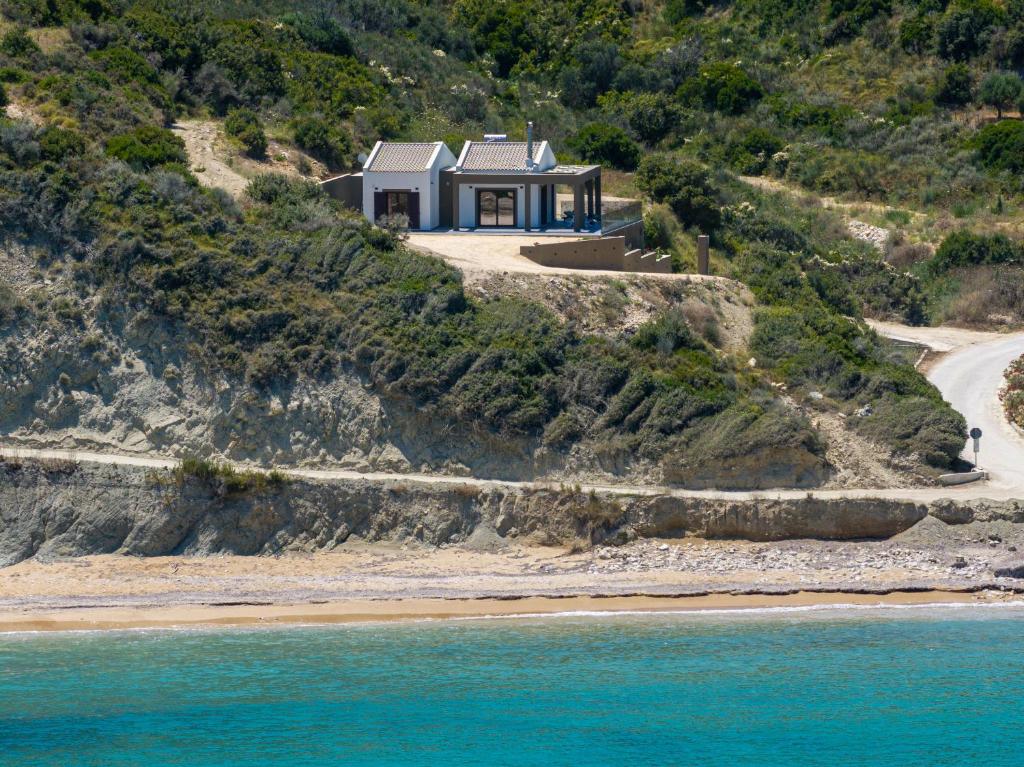 a house on a cliff next to the ocean at Beachfront Villa Fteri in Kefalonia