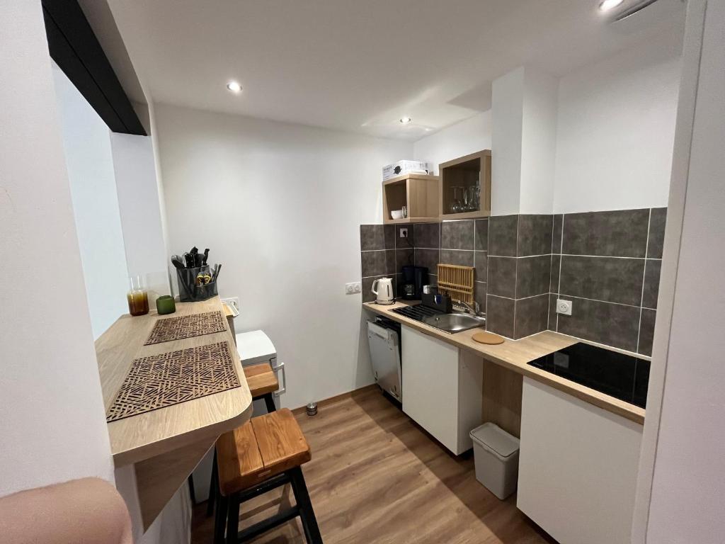 een kleine keuken met een tafel en een aanrechtblad bij La Rive in Le Bourg-dʼOisans