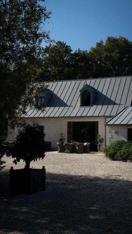 a white building with a gambrel roof at Domaine du Turbais in Luynes
