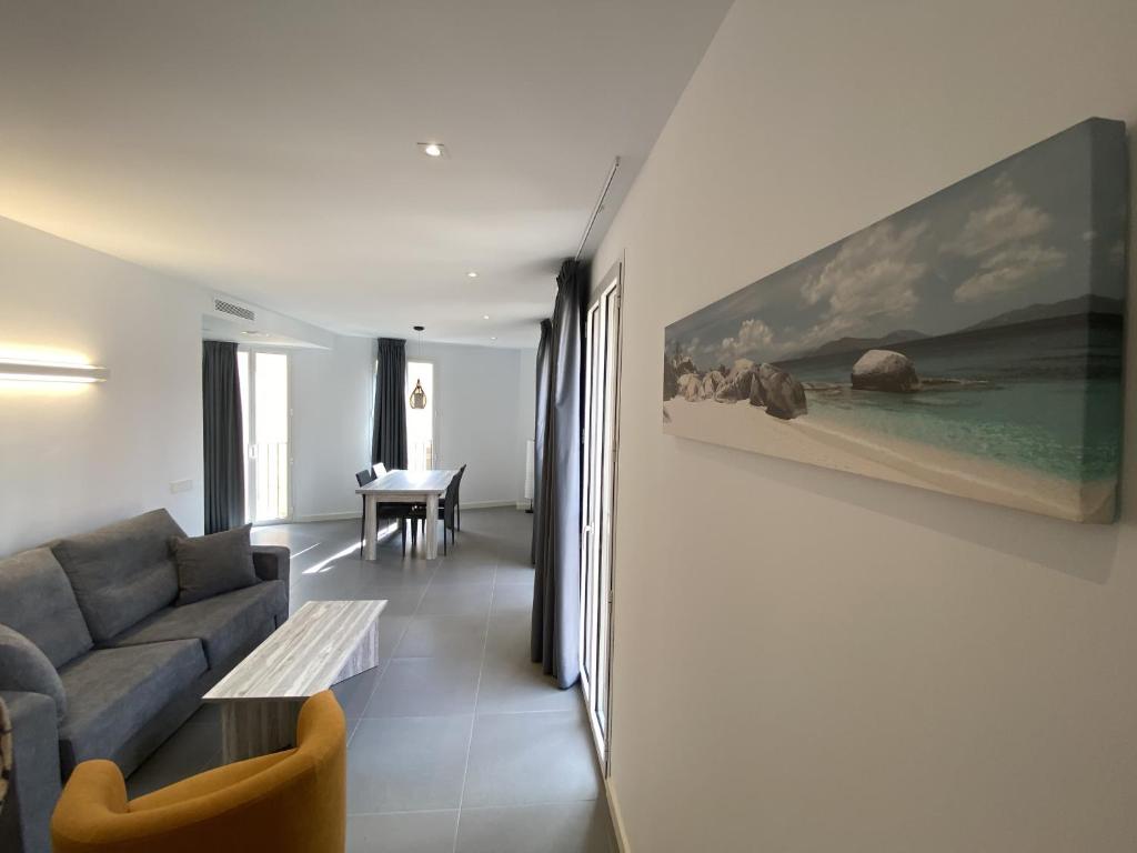 a living room with a couch and a painting on the wall at Can Calo 2B in Castelló d'Empúries