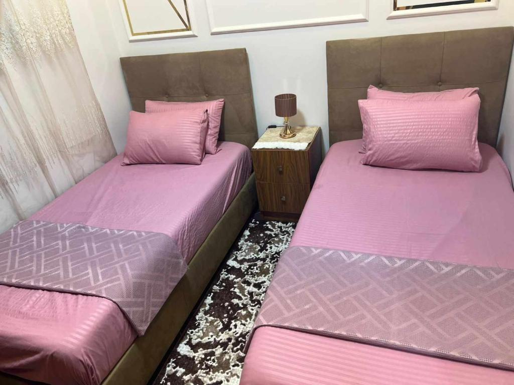 two beds in a room with pink sheets at بورتو مطروح - Porto Matrouh in Marsa Matruh
