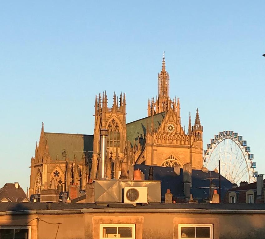 Une grande cathédrale avec une roue ferris devant elle dans l'établissement Le St-Arnould - Vue Cathédrale, central & calme, à Metz