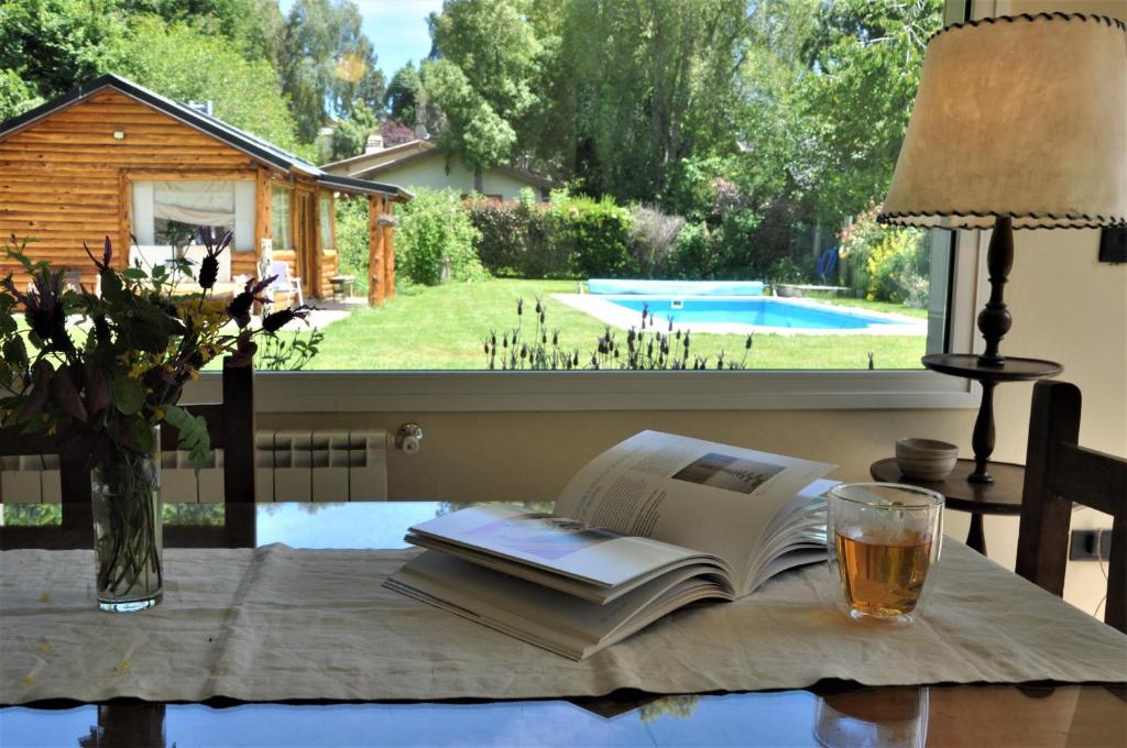 an open book on a table with a glass of beer at Casa Don Alfredo in San Carlos de Bariloche