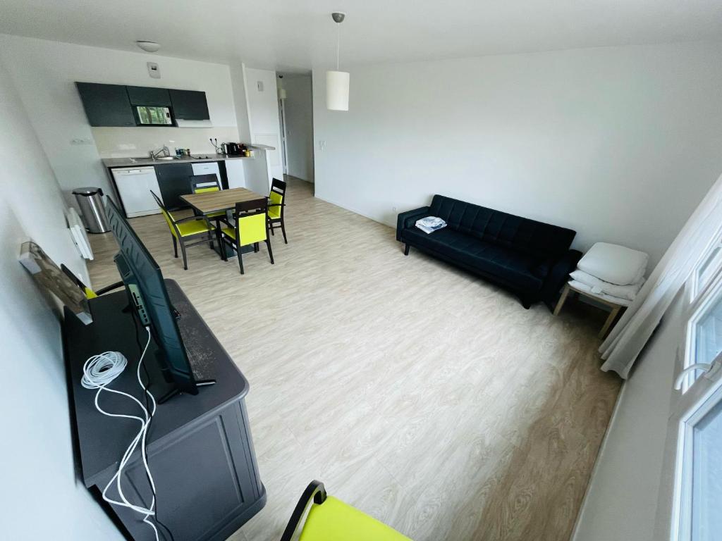 a living room with a flat screen tv and a couch at Rouen Confort - 395 in Rouen
