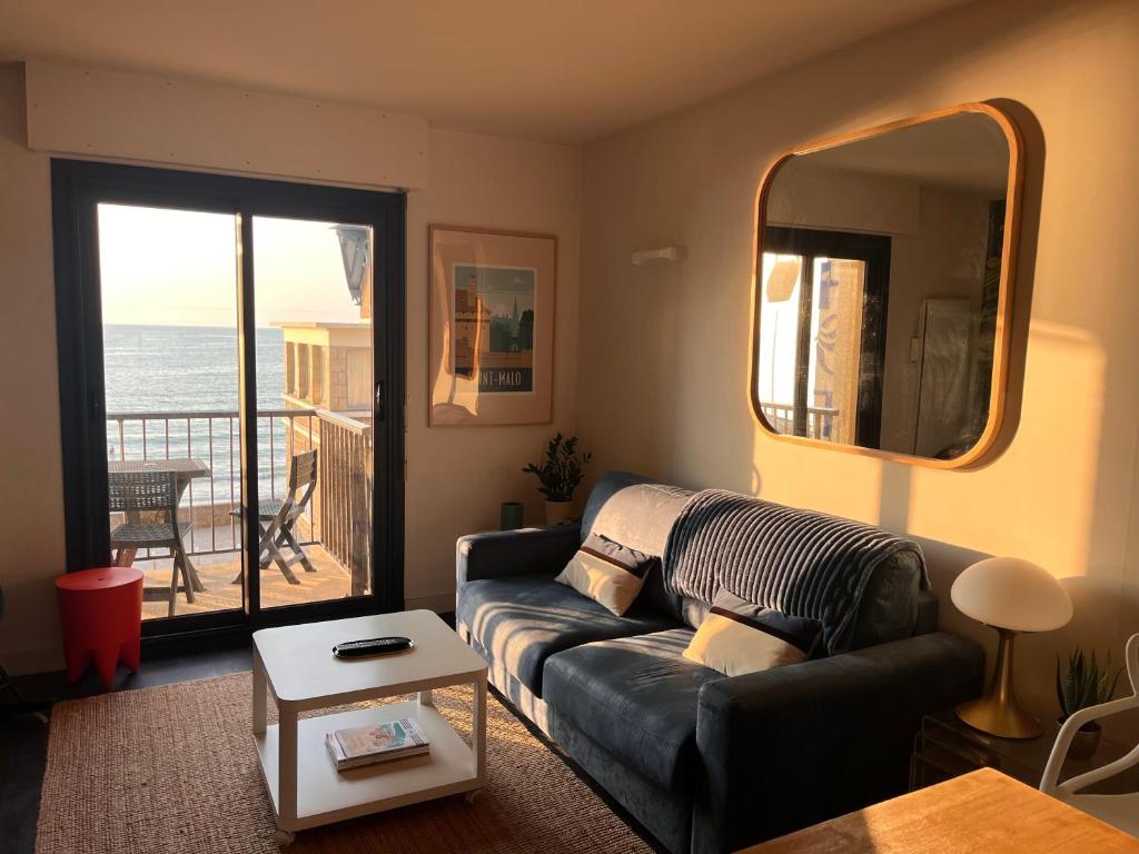 a living room with a couch and a view of the ocean at Emeraude, pleine vue de mer in Saint Malo