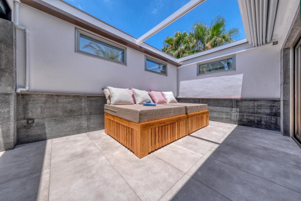 a room with a bench in the middle of a patio at Casita Max - Luxury - 1 min to the Beach By Lanzarote Vacation Homes in Costa Teguise