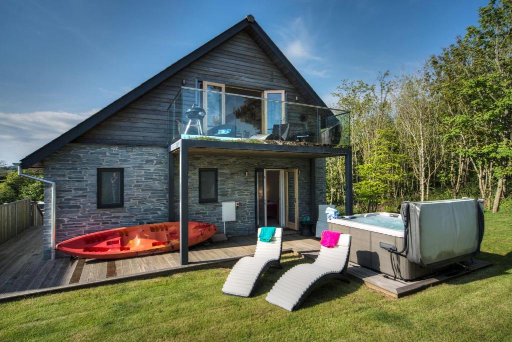 a house with a pool and a tv and chairs at House 27 in Looe