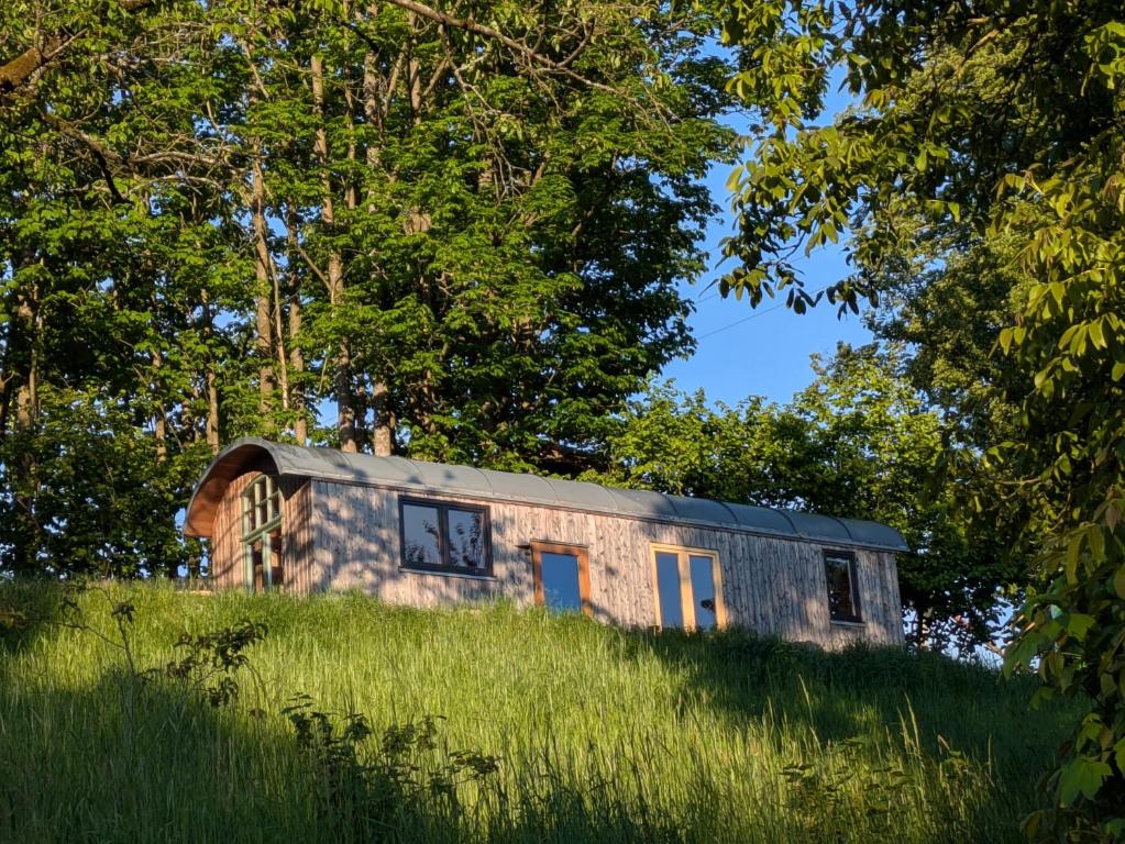 a stone house on top of a grassy hill at Tiny House - Natur und Komfort in Kulmbach