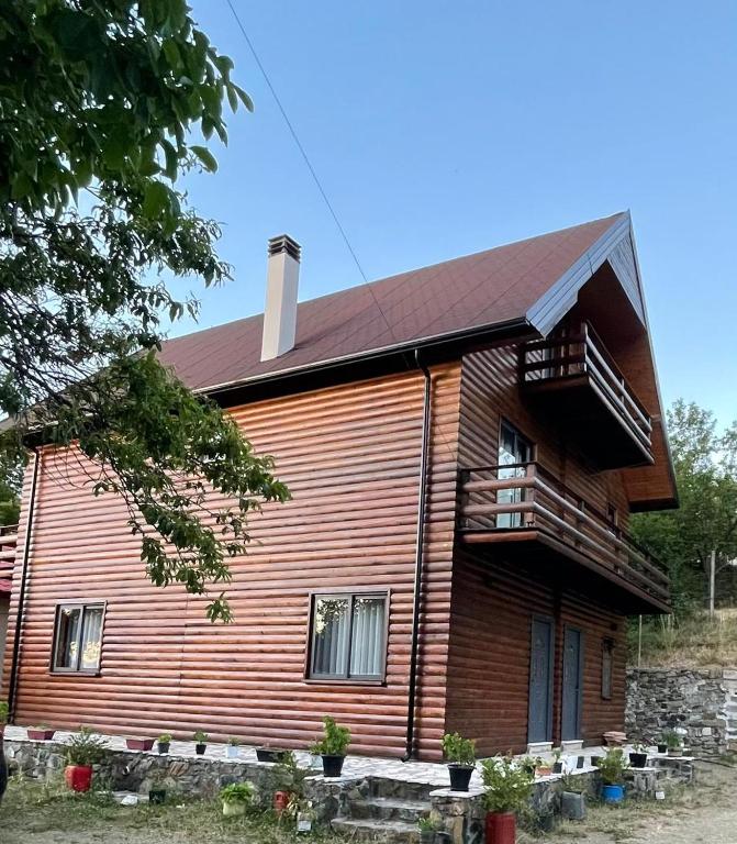 a large wooden house with a porch and a balcony at Mirjana Guesthouse in Pukë