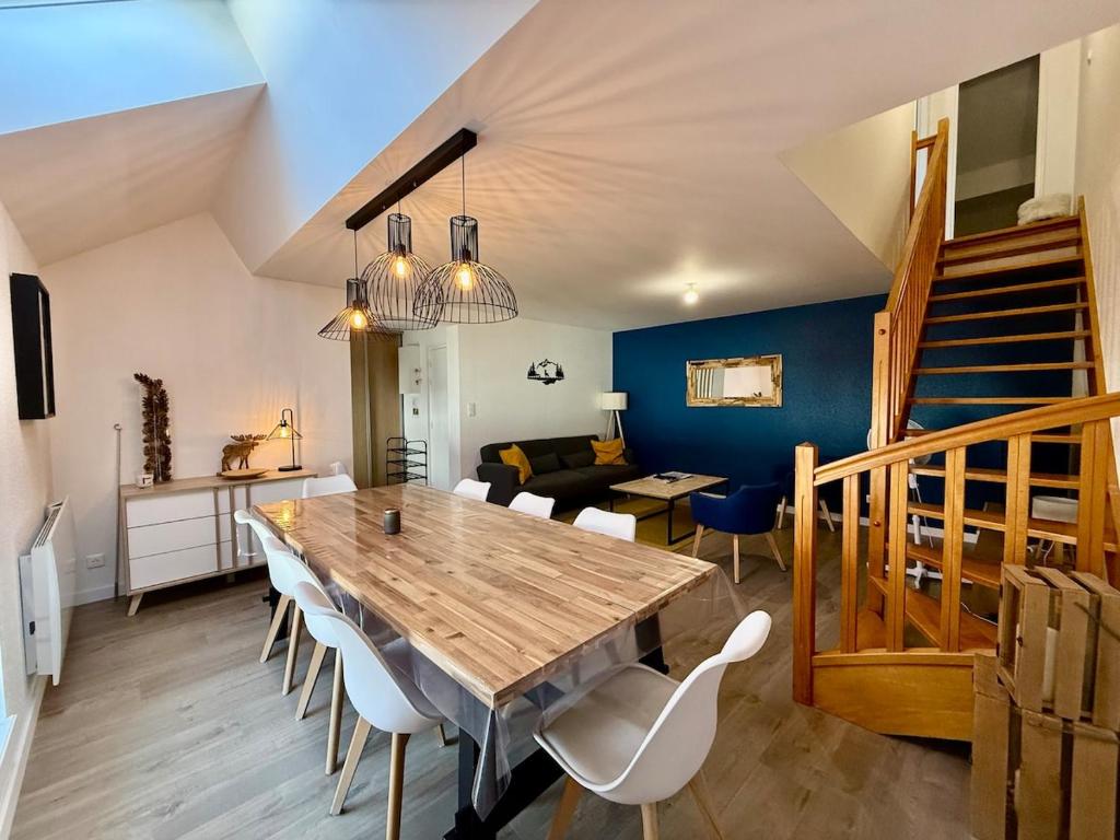 a dining room with a wooden table and chairs at L'Appart des Copains, beau duplex & centre-ville in Gérardmer