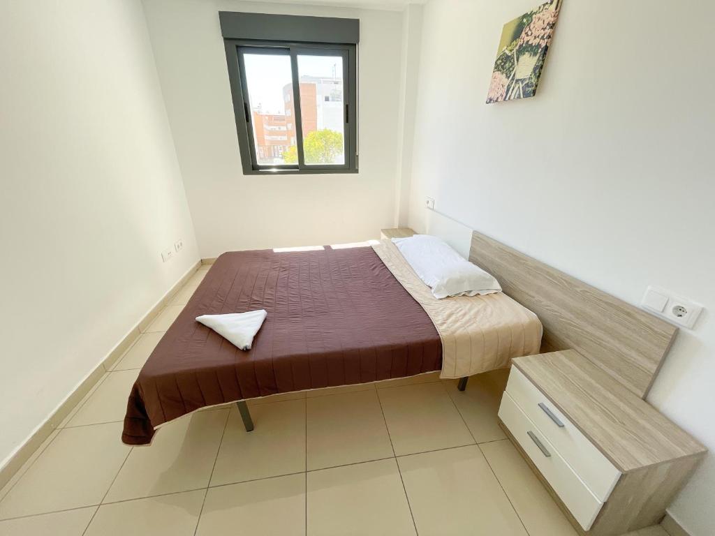 a small bed in a white room with a window at Apartamentos Lowcost Benicarlo 3000 in Benicarló
