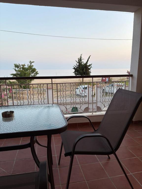 a table and a chair on a balcony at Aithra House Αίθρα in Toroni