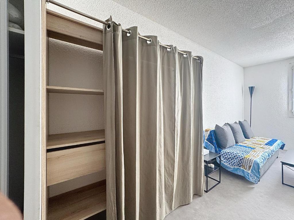 a room with a bed and a closet with curtains at Studio meublé à Lyon Centre in Lyon