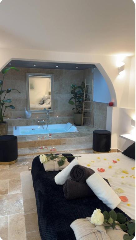 a bedroom with a large bed and a bath tub at Suite Prestige in Codolet