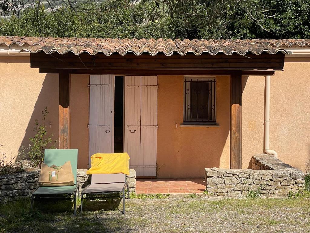 deux chaises assises sous un belvédère devant une maison dans l'établissement Deux mini villas distancees 10 metres pour 6 personnes, à Saint-Florent