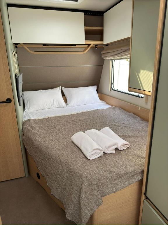 a bed in an rv with two white towels on it at On Wheels by Yerra in Yervandashat