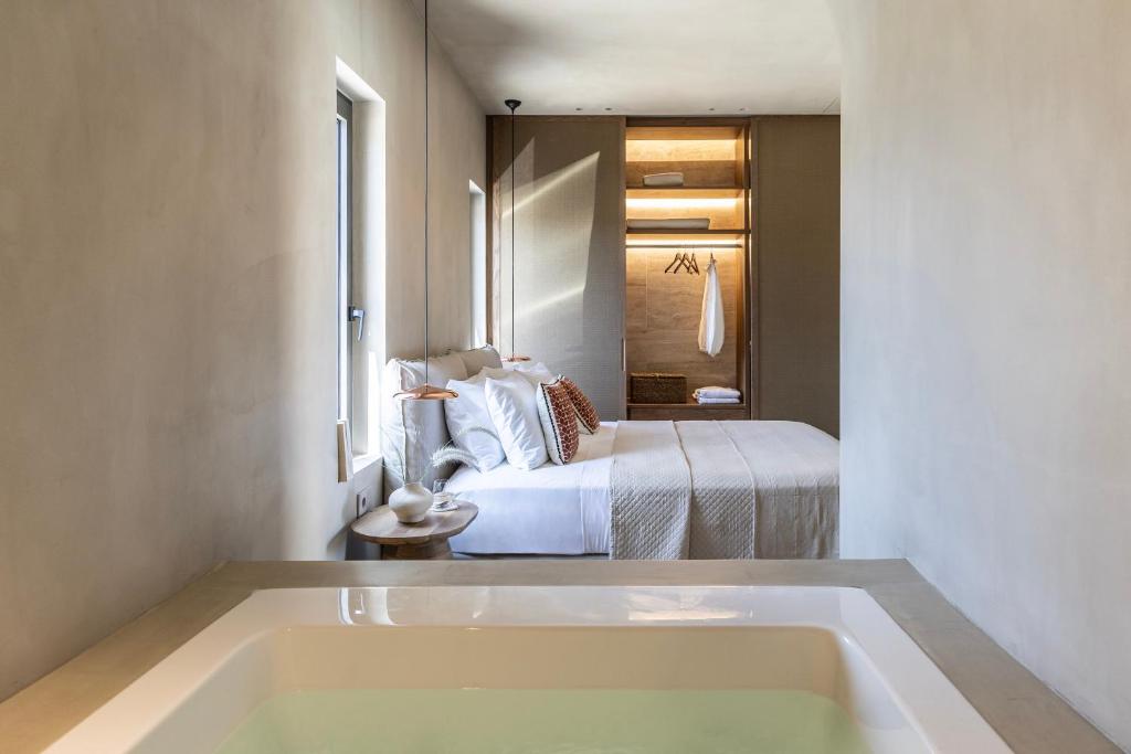 a bath tub in a room with a bed at Elea Luxury suites in Kardamaina