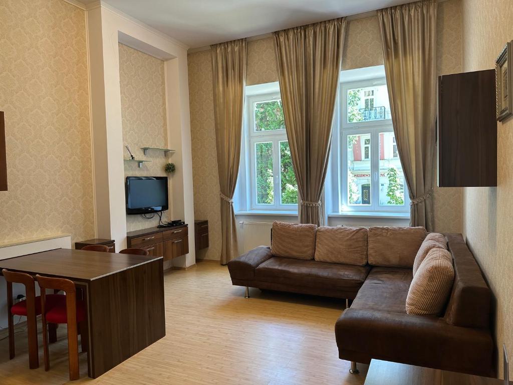 ein Wohnzimmer mit Couch und Tisch in der Unterkunft Apartment Sadova Karlovy Vary in Karlsbad