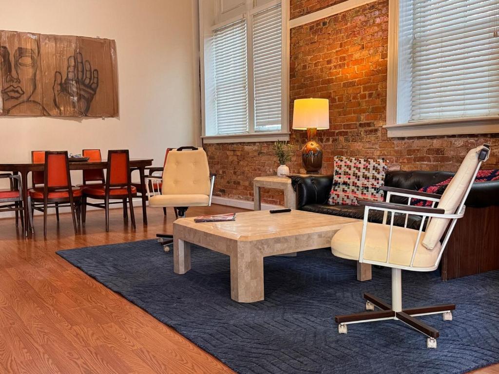 un soggiorno con un divano, un tavolo e delle sedie di Loft-Style Gem in 1911 Building a Elloree