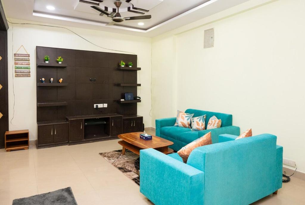 ハイデラバードにある3 BHK Apartment in Gachibowli near Delloite AIGのリビングルーム(青い椅子2脚、テーブル付)