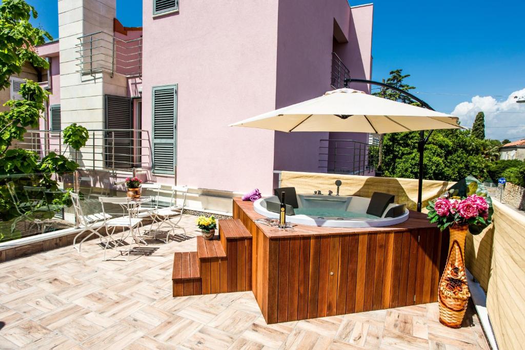 einen Whirlpool mit Sonnenschirm auf einer Terrasse in der Unterkunft Villa Violeta in Split