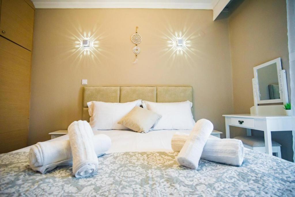a bedroom with a bed with white pillows on it at DESIGN HOMe in Paleo Tsifliki