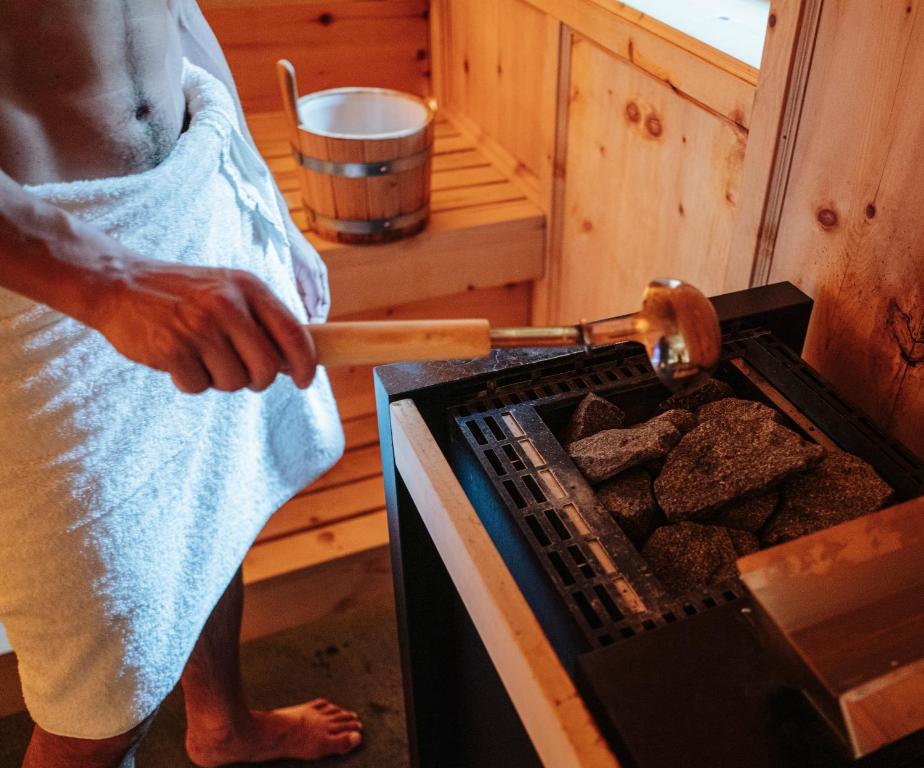 a man in a towel cooking food in an oven at La Genzianella Bormio in Bormio