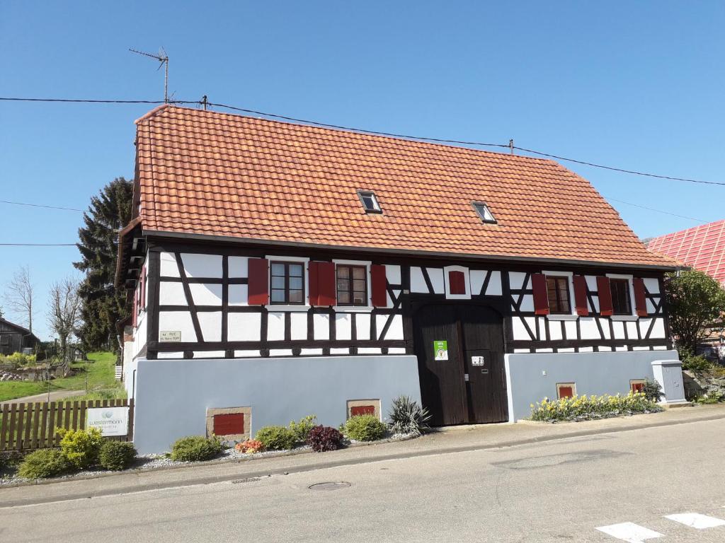 a black and white building with a red roof at La Petite Ferme d'Albert 