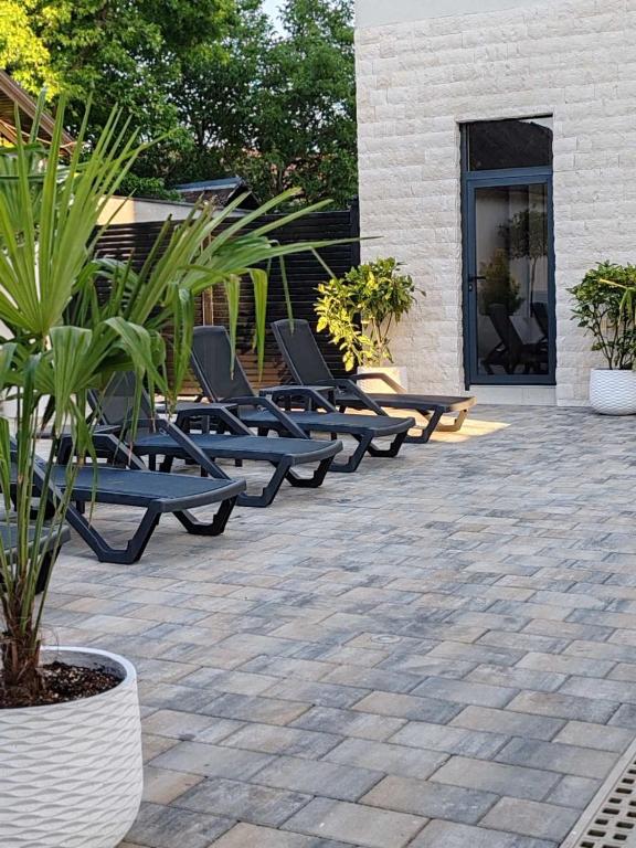a row of lounge chairs sitting on a patio at POOL RESORT- Vila Lena- Studio 3 in Vrdnik