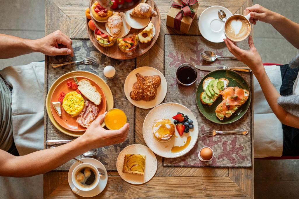 a group of people sitting at a table eating breakfast at La Genzianella Bormio in Bormio