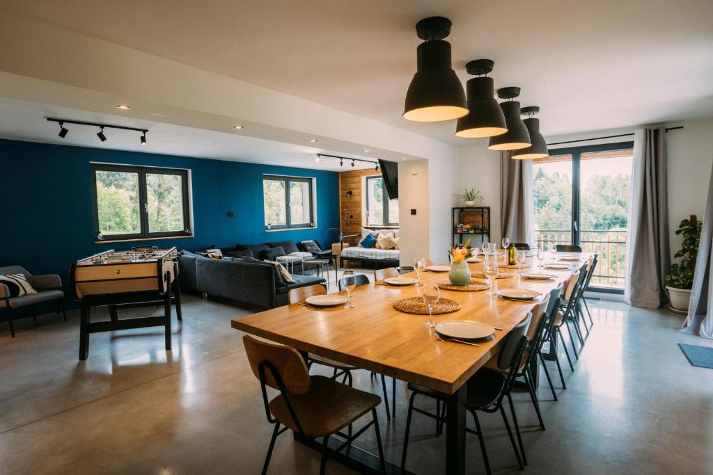 una sala da pranzo e un soggiorno con un grande tavolo in legno di CHALET LA FOUGERE 15 personnes 180m2 bauges Savoie Thoiry a Thoiry
