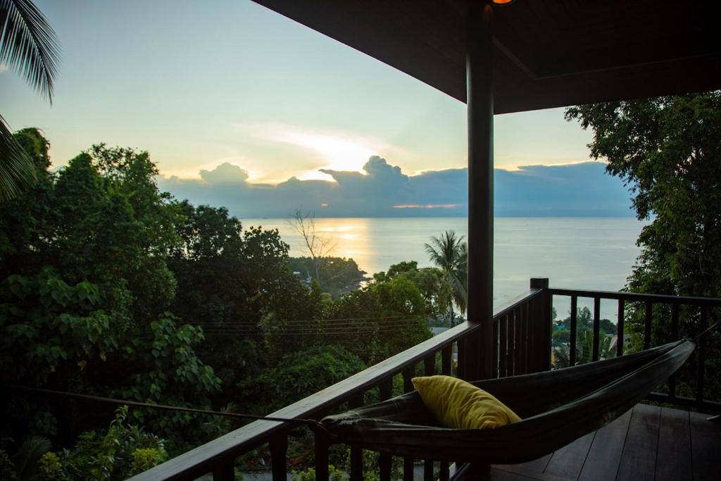 a hammock on a balcony with a view of the ocean at Baan Talay in Salad Beach