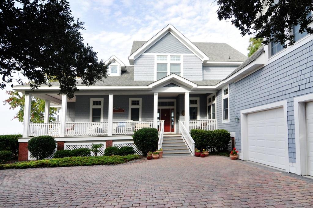 a white house with a porch and a driveway at Live Oak Landing in Corolla
