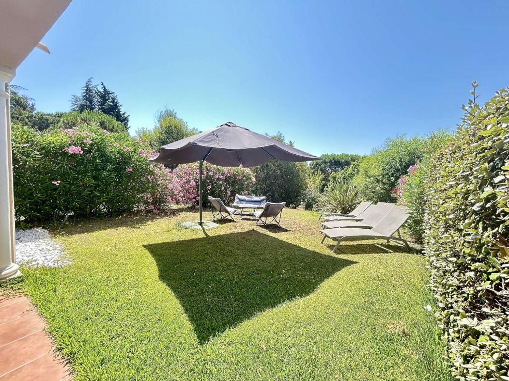 un patio avec un parasol, une table et des chaises dans l'établissement Sainte-Maxime: Appart 3P climatisé avec piscine, parking privé et jardin calme - FR-1-226-471, à Sainte-Maxime