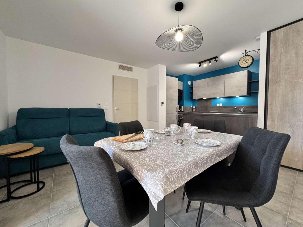 una sala da pranzo con un tavolo e un divano verde di Appartement 3 pièces climatisé avec parking - Saint-Cyr-sur-Mer - FR-1-845-3 a Saint-Cyr-sur-Mer