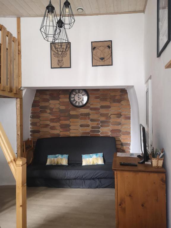 - un salon avec un canapé et une horloge murale dans l'établissement CAUTERETS Appart centre ville et calme idéal pr rando, ski et cure, à Cauterets